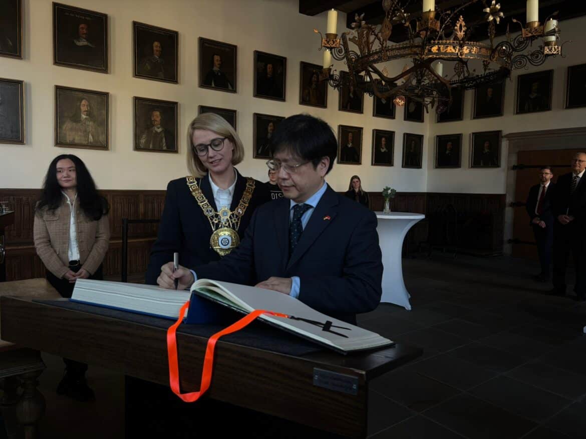 Generalkonsul Dong Lin trägt sich im Goldenen Buch ein.