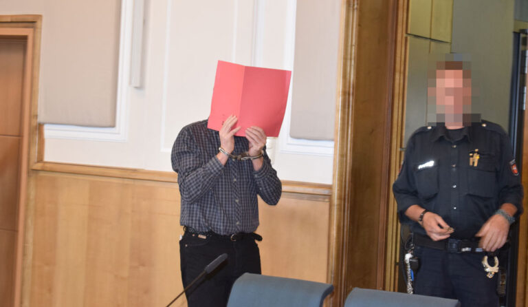 Der Angeklagte versteckte sich bei Prozessbeginn hinter einem Aktendeckel