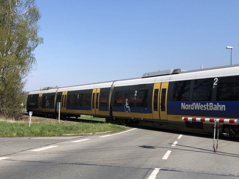 Zug der NordWestBahn auf einem Bahnübergang