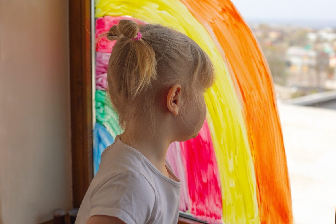 Kleines Mädchen mit Regenbogen-Bild