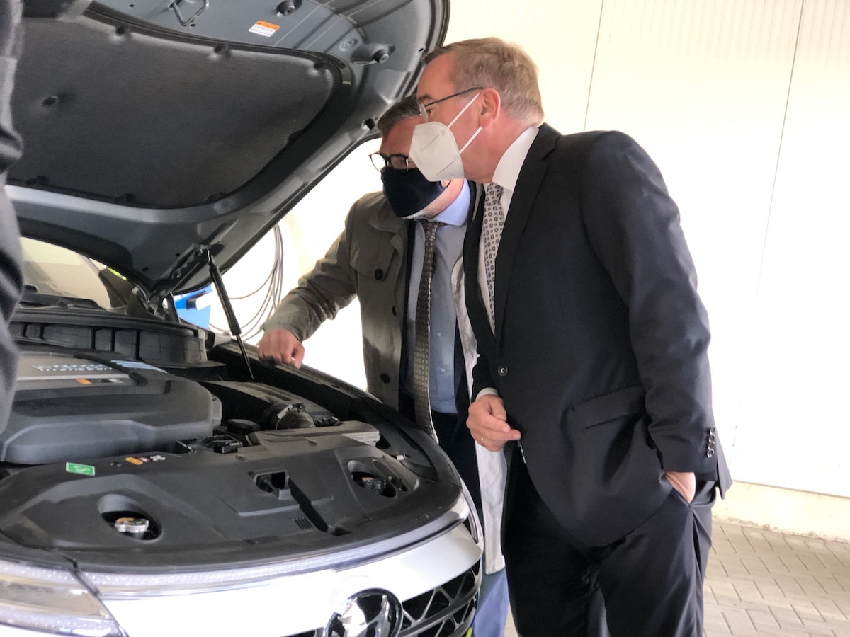 Polizeipräsident Michael Maßmann und Innenminister Boris Pistorius sehen sich die Plastikabdeckung unter der Motorhaube an