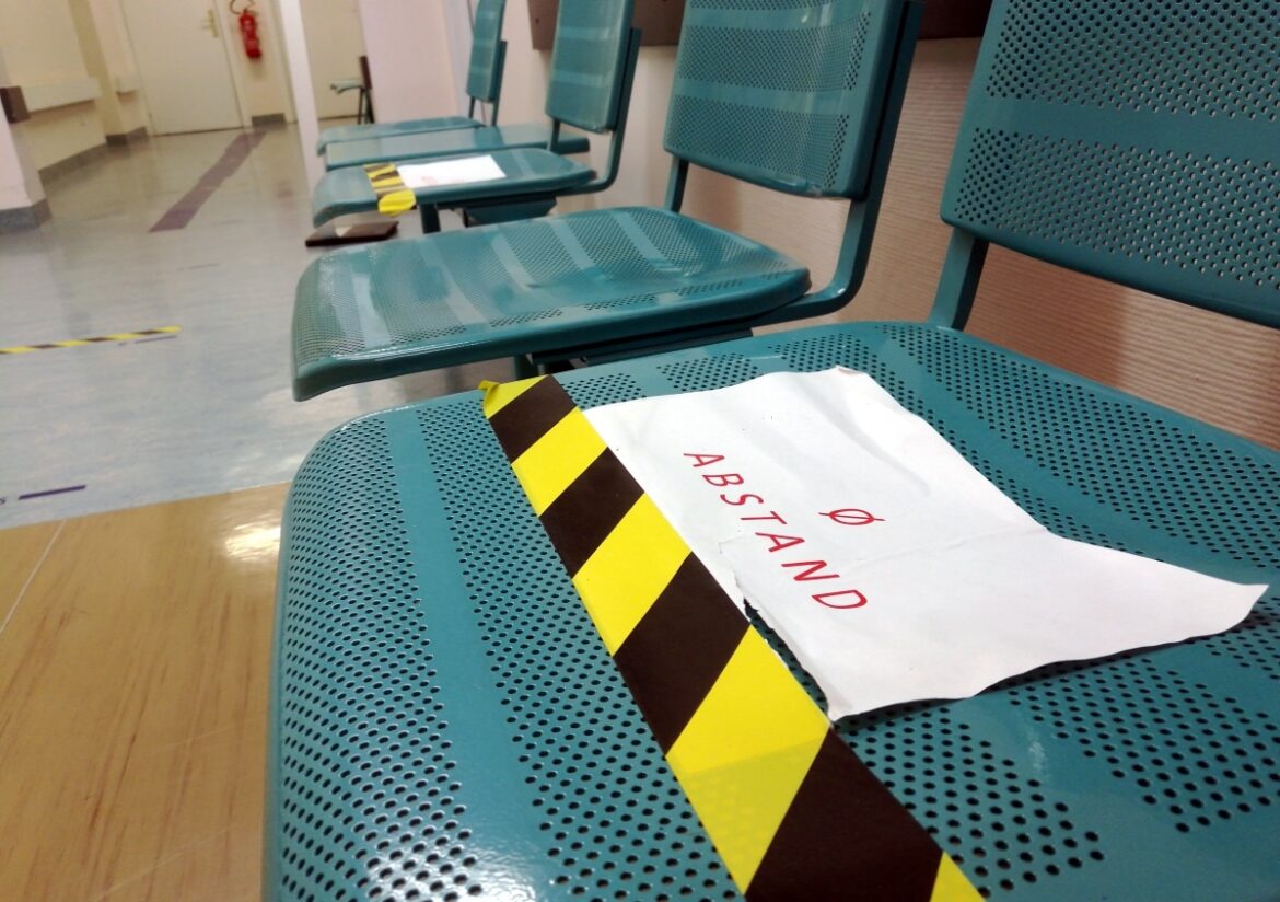 Sitzbänke mit Corona-Abstandshinweis im Krankenhaus