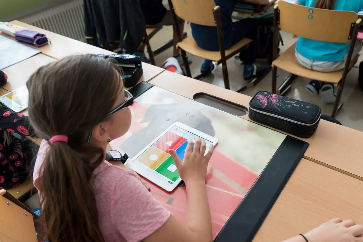 Grundschülerinnen und Grundschüler lernen an iPads.