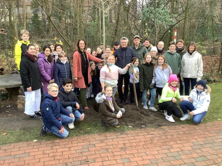 Fritz Brickwedde, Vorsitzender der Stiftung Osnabrücker Club, und Schulleiterin Daniela Boßmeyer-Hoffmann umringt von an der Baumpflanzaktion beteiligten Schülerinnen, Schülern und Lehrkräften. / Foto: Ursulaschule Osnabrück