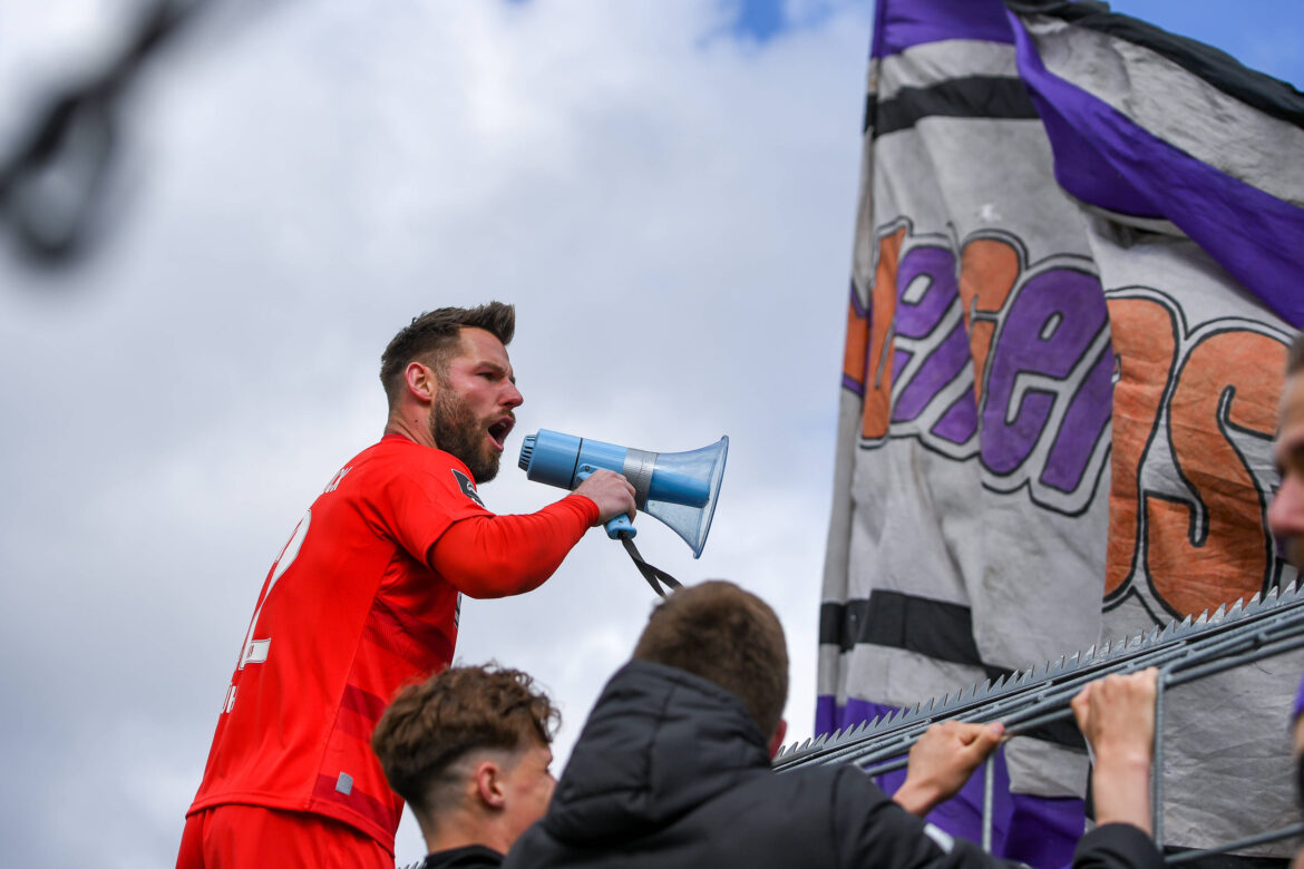 VfL-Keeper Philipp Kühn mit Megaphon auf dem Zaun in Grünwald beim TSV 1860 München; Foto: IMAGO / foto2press