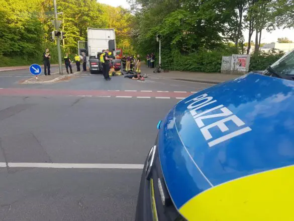 Polizei und Rettungskräfte bei Fahrrad unter LKW