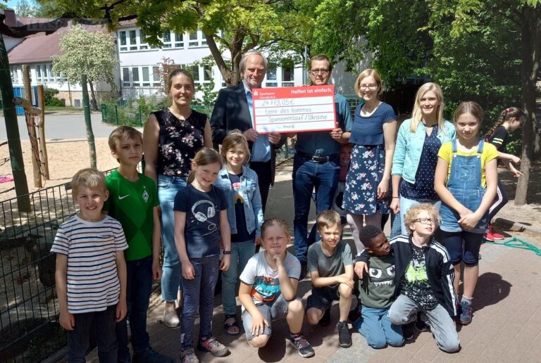 v.l.n.r.: Ann Kathrin Wilker (stellvertretende Schulleiterin), Stephan Stolze (terre des hommes), Sascha Krolik (Förderverein Waldschule), Janin Klute (Lehrerin) und Katharina Robbe (Lehrerin) freuen sich gemeinsam mit den Grundschülern über die Spende. / Foto: Brockfeld