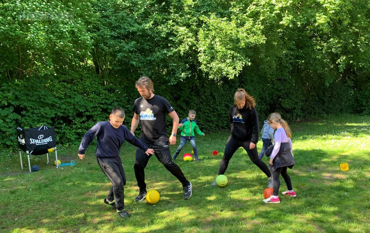 (von links) Stefan Wessels und Miriam Dannemann bolzen mit den Kindern. / Foto: Schweer