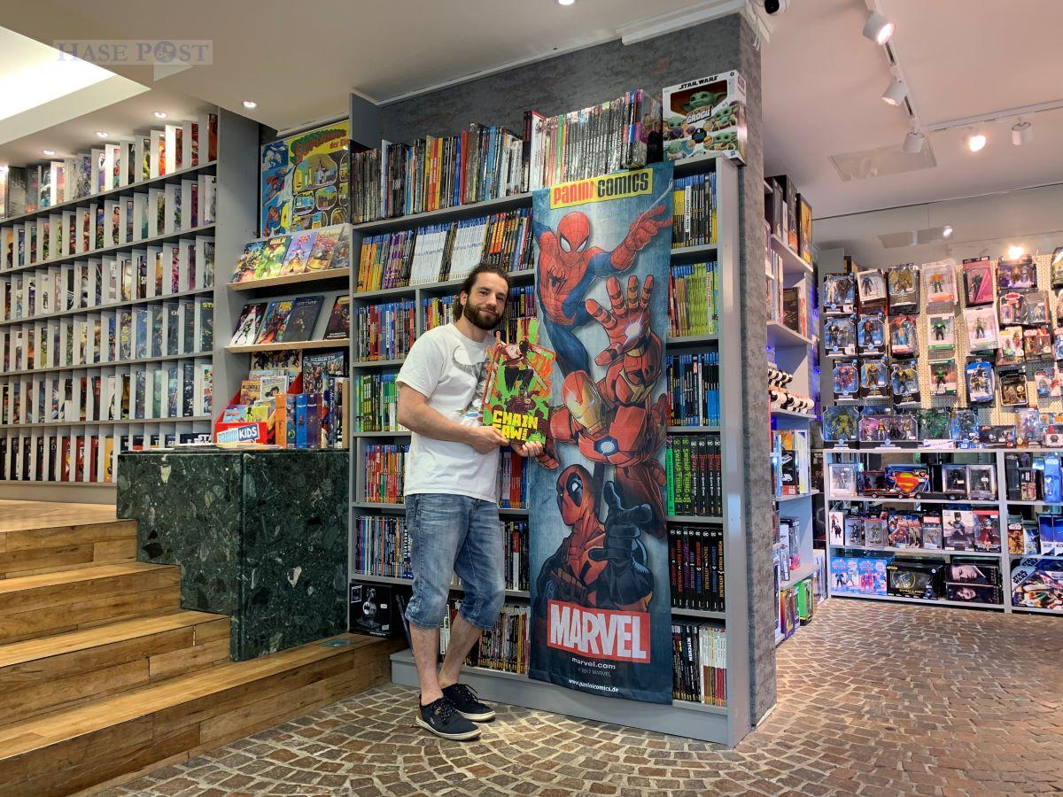 Filialleiter Perry Pallaske präsentiert zwei der Banner, die bei der Aufstellerversteigerung für den guten Zweck versteigert werden. / Foto: Schweer