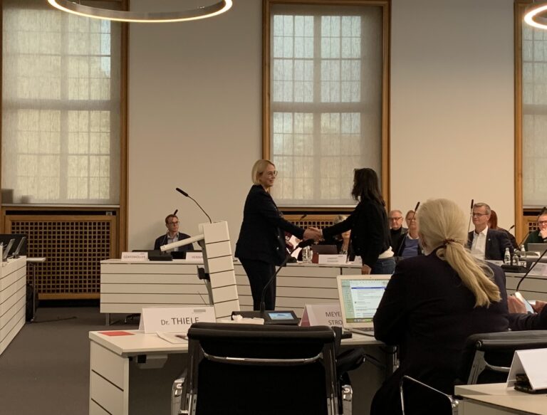 Oberbürgermeisterin Katharina Pötter begrüßt Loreto Bieritz per Handschlag im Stadtrat. / Foto: Guss