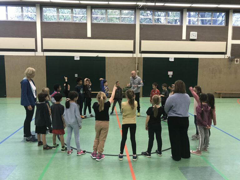 Coach Oliver Henneke spielt mit den Kindern der Elisabeth-Siegel-Schule in der Sporthalle. / Foto: Burrichter