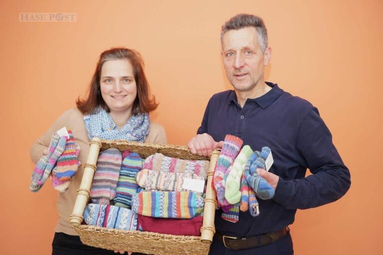 Miriam Buhl und Ottmar Stephan vom Caritasverband für die Diözese Osnabrück verkaufen bunte Wollsocken für den guten Zweck. / Foto: Caritas / Nadin Kohlbrecher