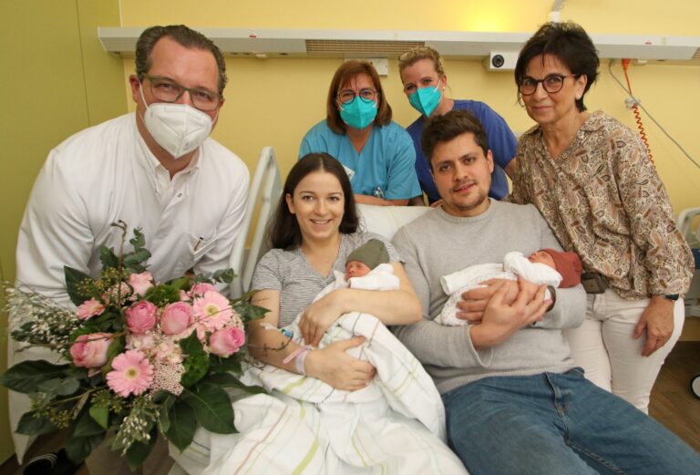 Gut gelaunt mit neuen Erdenbürgern: Stolze Eltern Neele und Nabil Khan mit Elina und Amaya, Großmutter und Hebamme Martina Tiedemann (r.) sowie (v.l.) Geburtshilfe-Chefarzt Dr. Dr. Yves Garnier, Pflegeteamleiterin Birgit Santowski und der Leitenden Hebamme Anke Kramer. / Foto: Jens Lintel