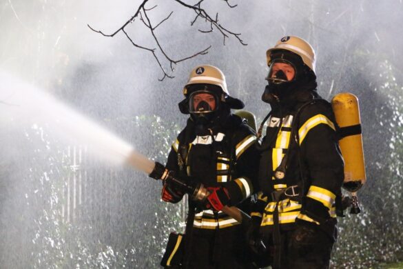 Einsatztrupp unter Atemschutz an Strahlrohr von vorne