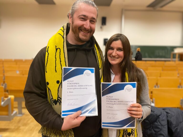 (von links) Der Künstler Leon Hinrichsmeyer und die Künstlerin Clara Uhlemann von der Uni Osnabrück haben die mit je 2.000 Euro dotierten Ingeborg-Sieber-Kunstförderpreise erhalten sowie als weitere Trophäe einen Schal von Künstlerin Anna Haifisch, der als Edition von der Kunsthalle Osnabrück herausgegeben wurde. / Foto: Uni Osnabrück