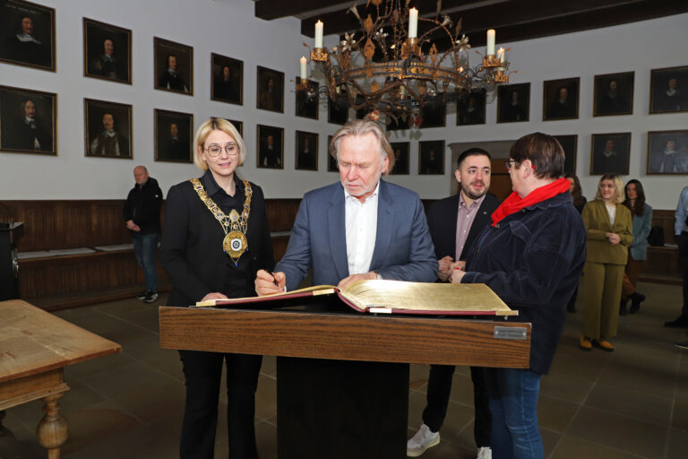 Der Australische Botschafter Philip Green (2. von links) trägt sich im Beisein von Oberbürgermeisterin Katharina Pötter (links) sowie den Bundestagsabgeordneten Manuel Gava und Anke Hennig ins Goldene Buch der Stadt Osnabrück ein. / Foto: Simon Vonstein