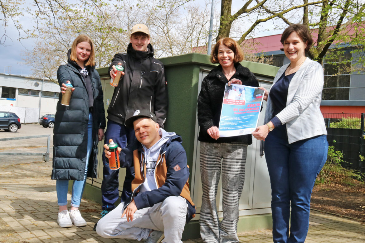 Alles startklar für die Sprayaktion an der Realschule. Darüber freuen sich (von links): Sarah Brüggemann (Auszubildende Stadt Georgsmarienhütte), Max Schmidt (Auszubildender Stadtwerke Georgsmarienhütte), Graffiti-Künstler Christian Borchert, die städtische Jugendpflegerin Martina Möllenkamp und die Leiterin der Personal- und Rechtsabteilung bei den Stadtwerken Georgsmarienhütte, Nina Fischer. / Foto: Stadt Georgsmarienhütte, Niklas Otten
