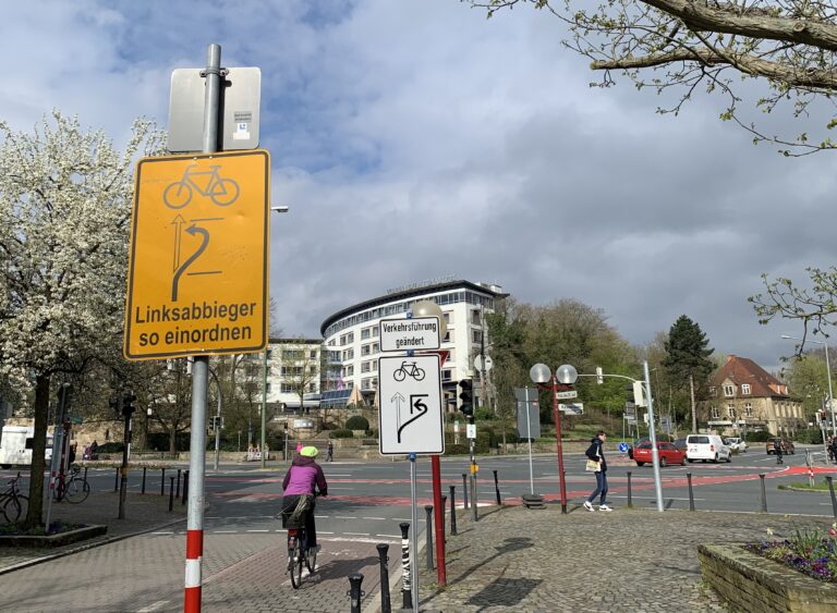 Zwei Schilder weisen derzeit auf eine Umstellung beim indirekten Linksabbiegen hin, wie hier etwa am Rißmüllerplatz. / Foto: Guss