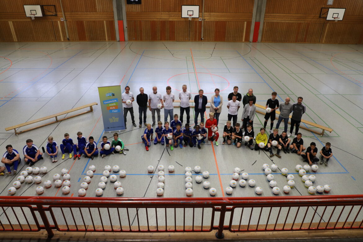 In Osnabrück wird Fairtrade großgeschrieben. Vor dem Turnier am Ernst-Moritz-Arndt-Gymnasium überreicht Bürgermeister Uwe Görtemöller 100 Bälle an die Osnabrücker Schulen. Mit dabei sind neben Schülerinnen und Schülern auch Vertreterinnen und Vertreter der Schulen, der Steuerungsgruppe Fairtrade-Town, des Startups BONTURA und des Osnabrücker Stadtrates. / Foto: Stadt Osnabrück (Simon Vonstein)