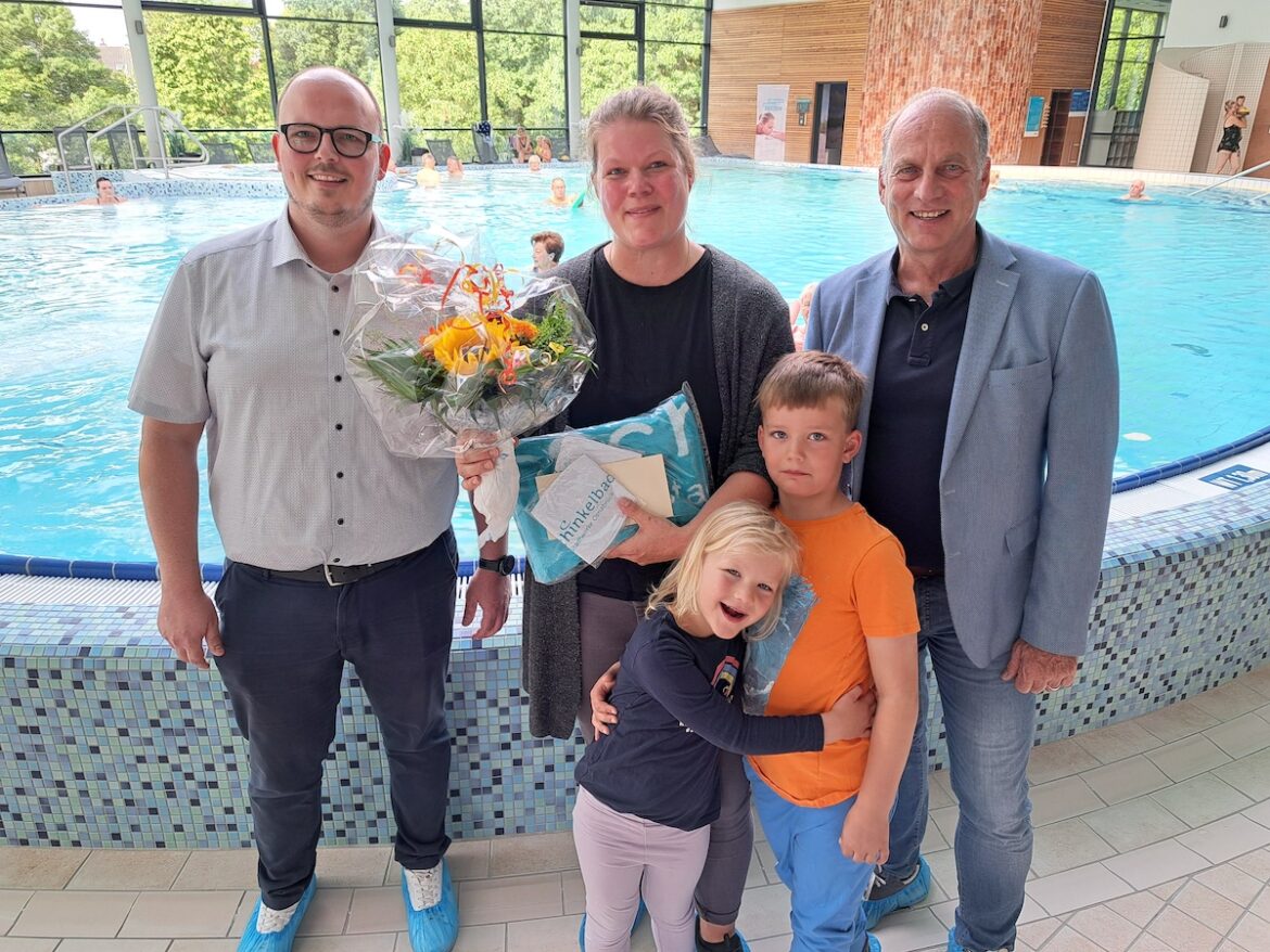 Imke Dransmann und ihre Kinder Tilda und Titus freuen sich über das Überraschungspaket aus der Hand von Stadtwerke-Bäderchef Wolfgang Hermle (rechts) und Schinkelbad-Leiter Jens Eick (links). / Foto: Stadtwerke Osnabrück / Marco Hörmeyer