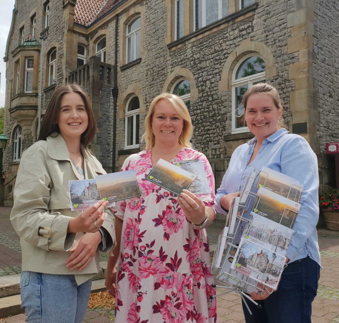 Präsentieren vor dem historischen Rathaus die neuen Postkarten mit Melle-Motiven: (von links) Maren Willenborg, Jutta Dettmann und Sabrina Bieschke. / Foto: Stadt Melle