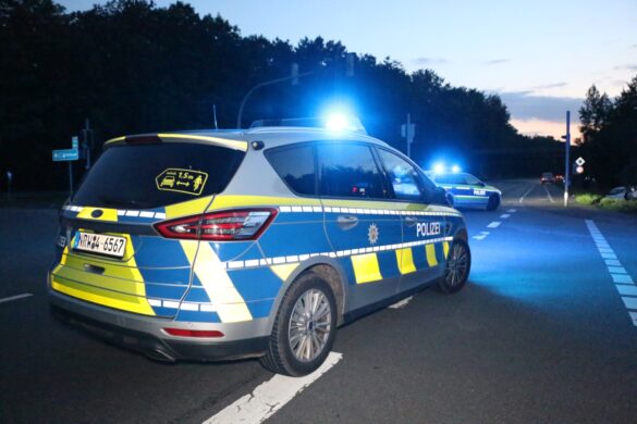 Streifenwagen an Unfallkreuzung in Dunkelheit