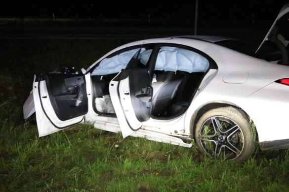 Seitenansicht demolierter PKW mit Gras im Hinterrad