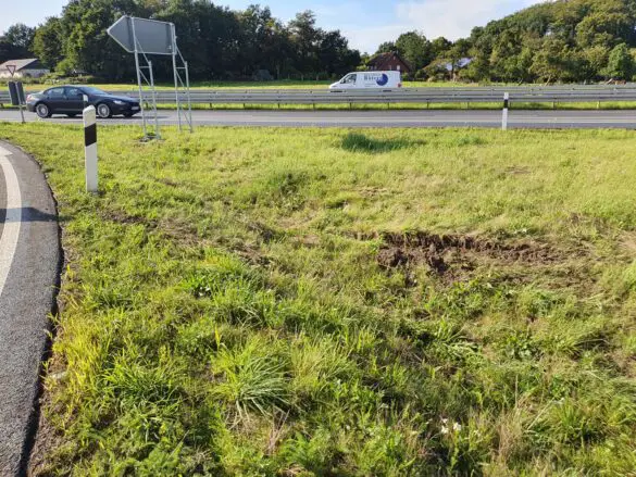 Reifenspuren in Grünfläche quer zur Fahrtrichtung