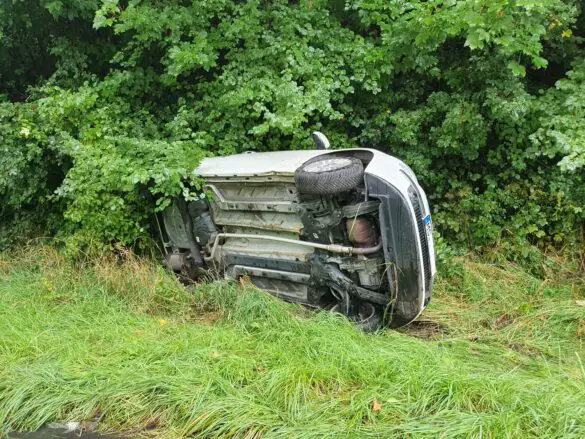 Umgekipptes Auto im Grünstreifen, seitliche Ansicht