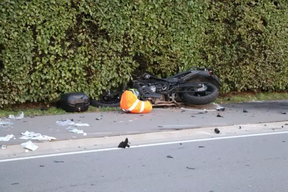 Motorrad auf Gehweg in Hecke