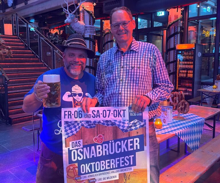 Chris Schäfer als bayrischer Wiesn-Repräsentant und Veranstalter Frederik Heede heben schon mal das Bier und Plakat für die zünftige Sause Anfang Oktober. / Foto: Agentur Schäfer