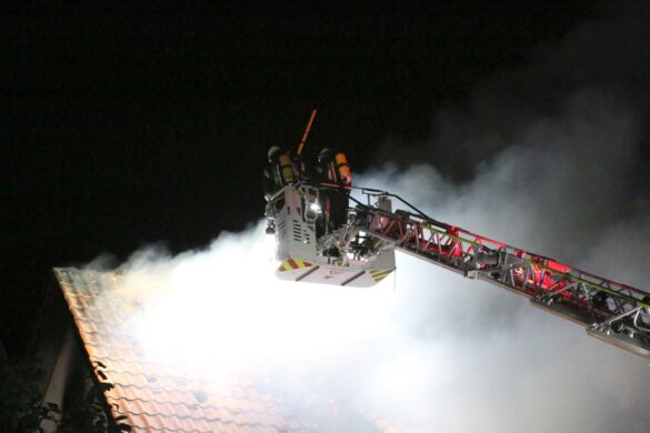 Drehleiterkorb vor Rauchwolke aus Dachstuhl