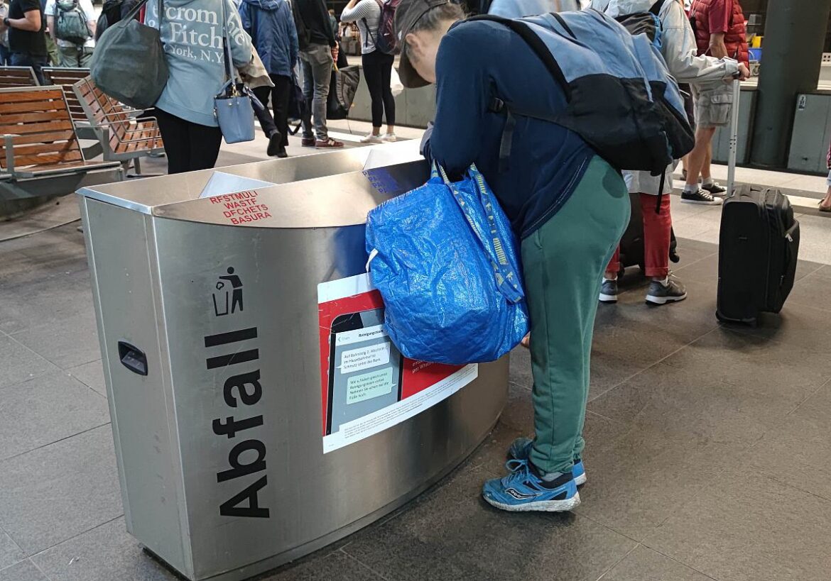 Pfandflaschensammlerin an einem Bahnhof
