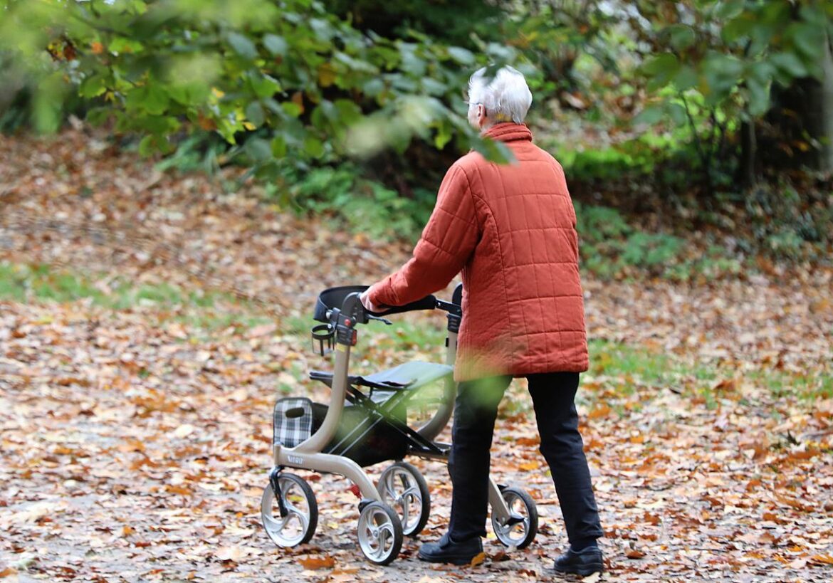 Frau geht am Rollator