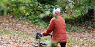 Frau geht am Rollator