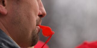 Mann mit Trillerpfeife im Mund