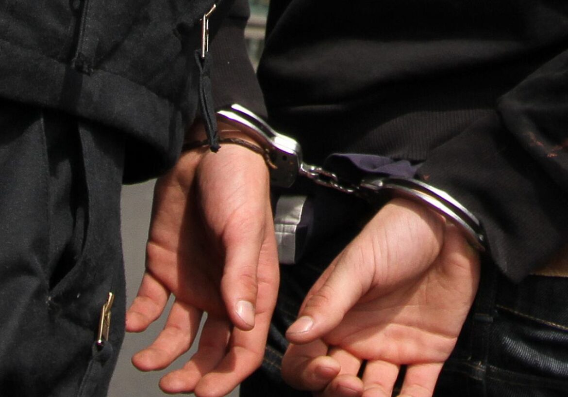 Hände in Handschellen auf dem Rücken