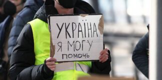 Person, die ein Schild mit ukrainischer Schrift hält