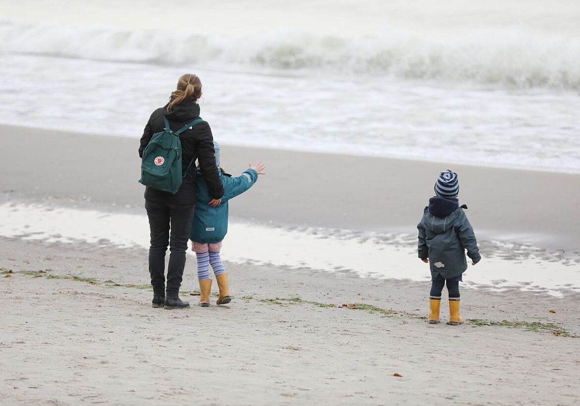 Mutter mit zwei Kindern am Strand