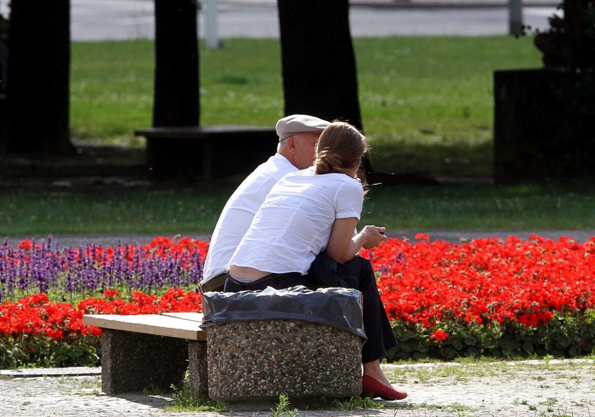 Personen sitzen auf einer Bank