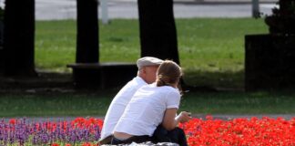 Personen sitzen auf einer Bank