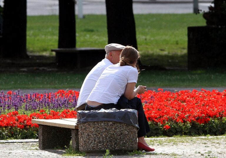 Personen sitzen auf einer Bank