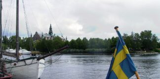 Boot auf einem See mit schwedischer Flagge.