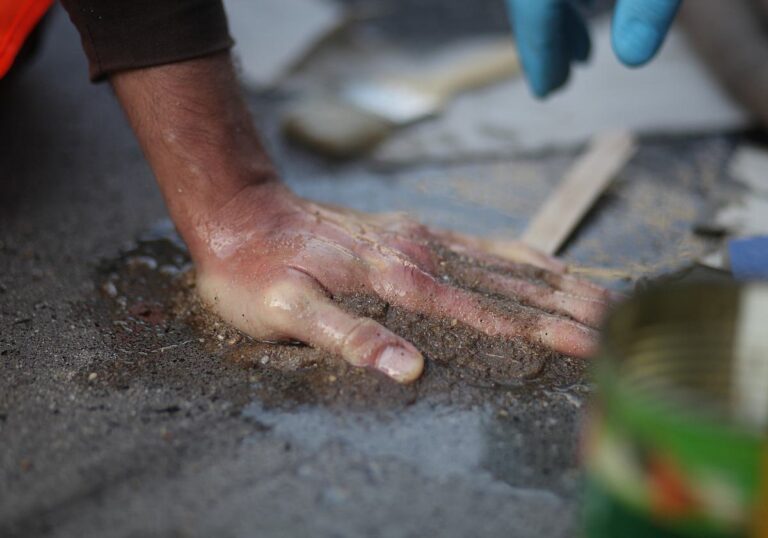 An Beton festgeklebte Hand