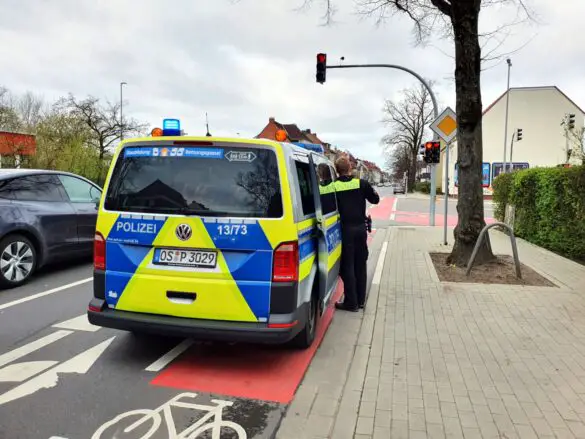 Beamter steht am Streifenwagen