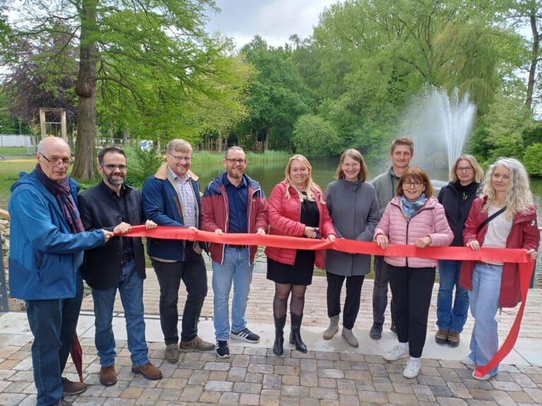 Mit dem Durschneiden eines roten Bandes nahm Bürgermeisterin Jutta Dettmann (Fünfte von links) die Einweihung des neugestalteten Grönenbergparks vor. Mit im Bild: (von links) George Trenkler, Uwe Plaß, Florian Schmeing, Thilo Richter, Manuela Völlmicke, Steffen Redemann, Gerda Hövel, Nadine Lemke und Iris Brune. /Foto: Stadt Melle