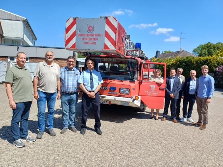 Fahrzeugübergabe im Sonnenschein mit (von links) Andreas Hafer, Alfred Reehuis, Bernd Gieshoidt, Achim Schlörmann, Jutta Dettmann, Konrad Schönberg, Dr. Robert Schönberg, Andreas Dreier und Roland Schönberg./Foto: Stadt Melle