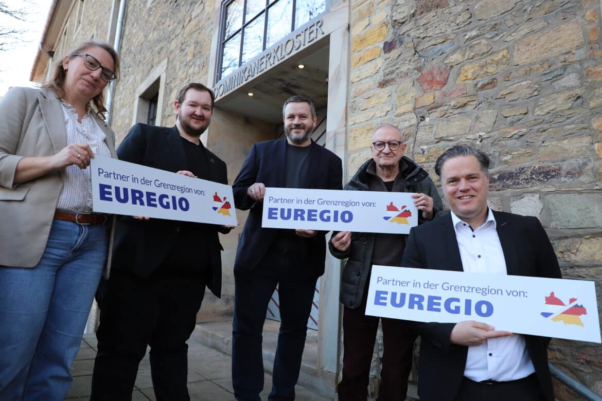 Sie präsentieren das neue EUREGIO-Schild (von links): Magdalena Knappik (Leitung Sachgebiet Stadt- und Regionalentwicklung), Lukas Ölmann (EUREGIO-Gremiumsmitglied), Hendrik Kettler (Koordinierungsstelle Regionale Kooperationen), Heiko Schlatermund (EUREGIO-Gremiumsmitglied) und Stadtbaurat Thimo Weitemeier. Es fehlt EUREGIO-Gremiumsmitglied Volker Witte./ Foto: Constantin Binder