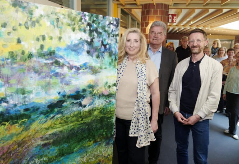 Gesine Elstermann präsentiert im Kreishaus Osnabrück eines ihrer Werke. An der Ausstellungseröffnung nahmen auch Kreisrat Matthias Selle (Mitte) und Fachdienstleiter Andreas Merse teil./Foto: Landkreis Osnabrück/Uwe Lewandowski in Nahne