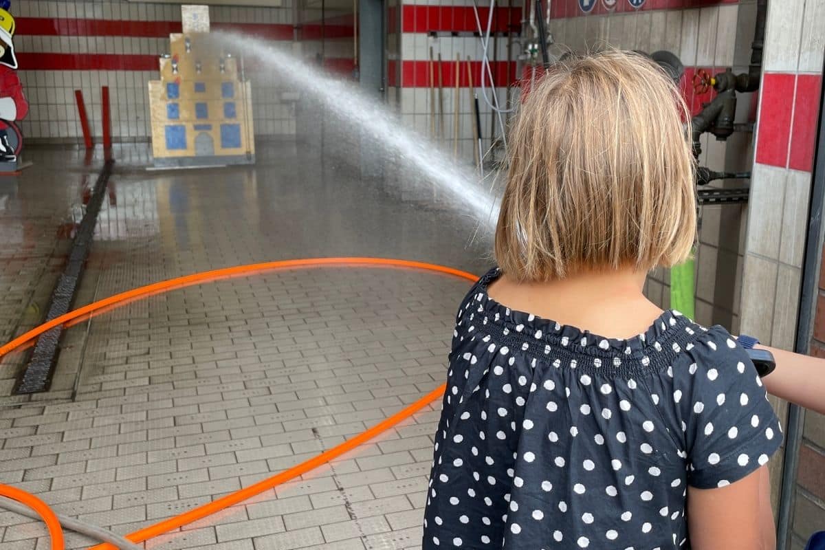 Kinder probieren sich am Feuerwehrschlauch aus. / Foto: Dominik Lapp